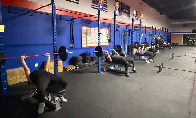Members bench pressing during Wentzville fitness class