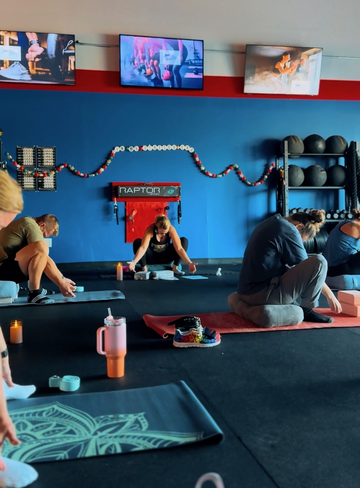 Women performing stretching and mobility exercises with kettlebells during group class at Freedom Fitness gym in St. Peters, Missouri